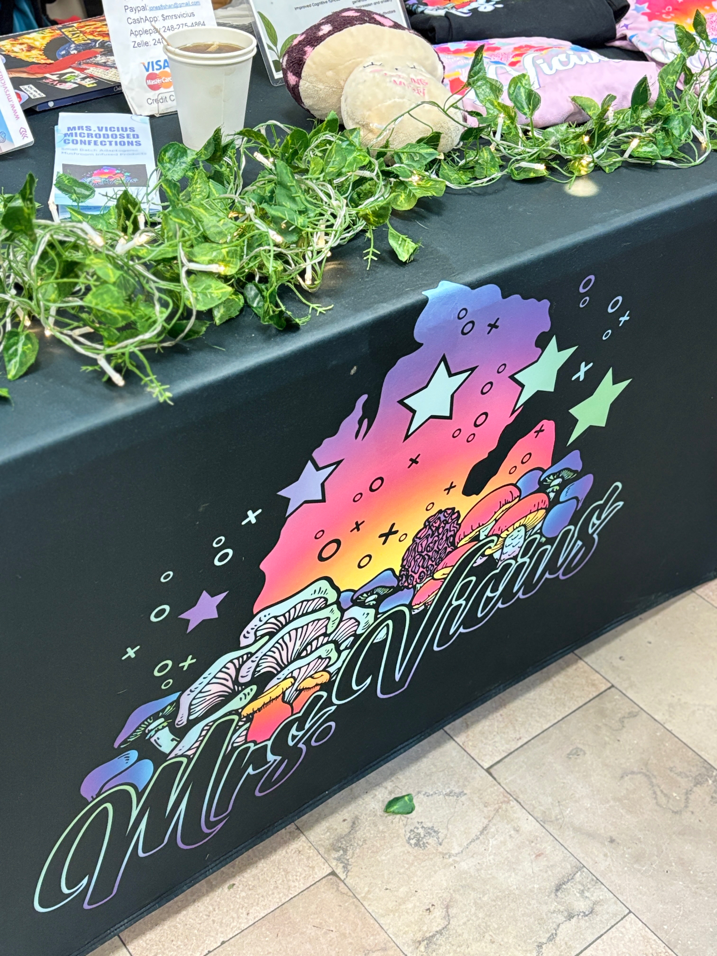 Colorful Mrs. Vicius mushroom artwork on a market table